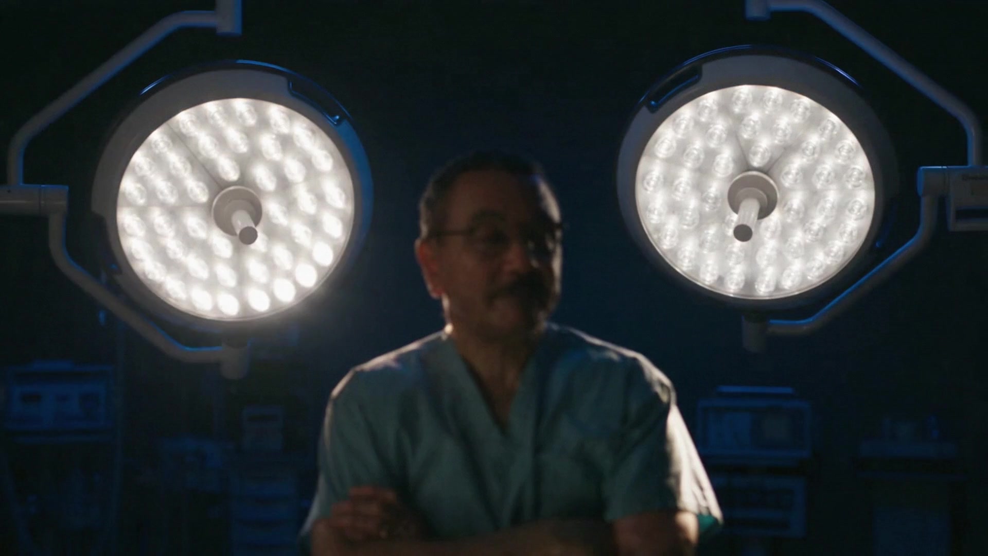 Dr. Kenrick Spence in the operating room under two surgical lights