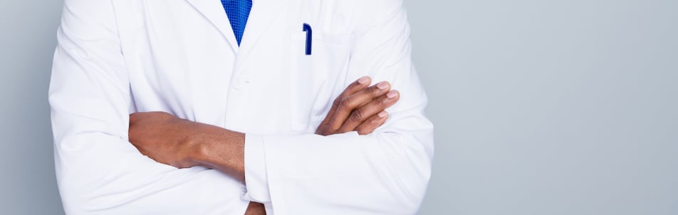 Doctor in a white coat standing with arms crossed