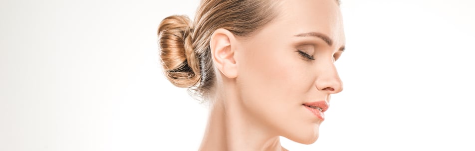 Side profile of a woman with hair in a bun and eyes closed
